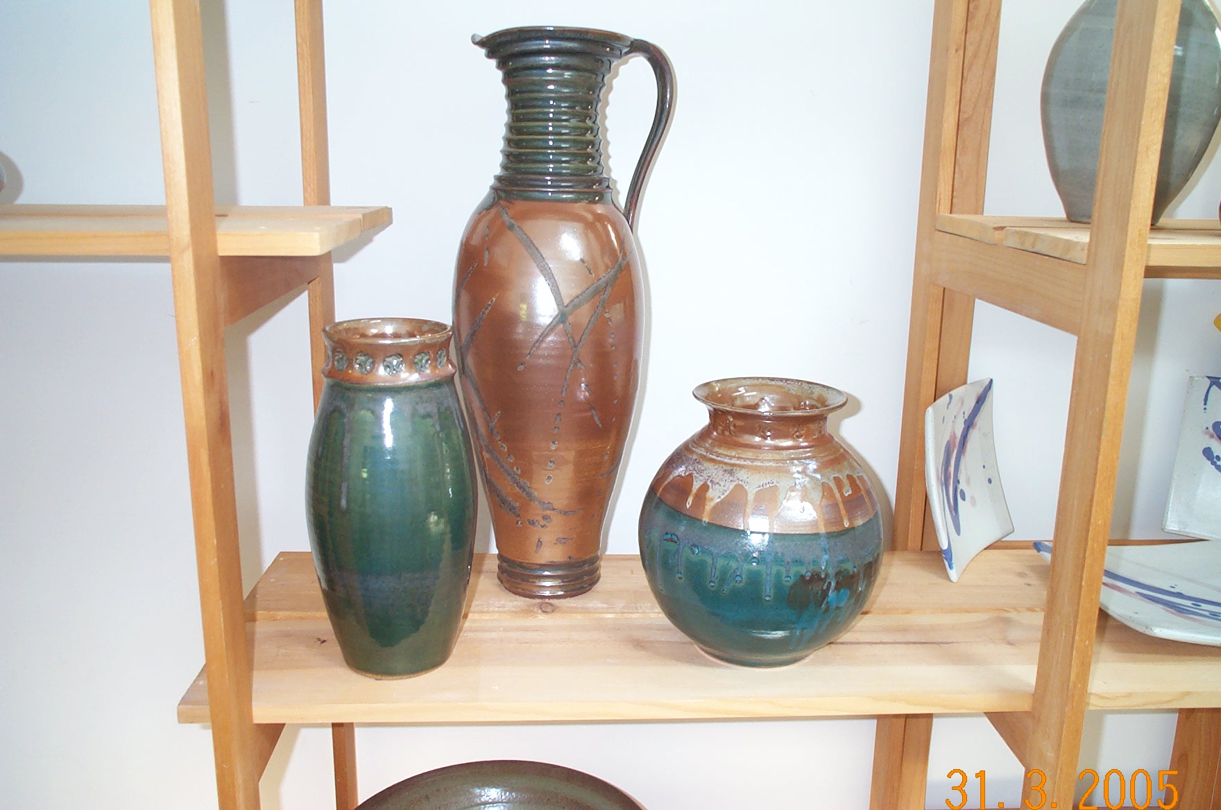 Thrown vessels on gallery shelves