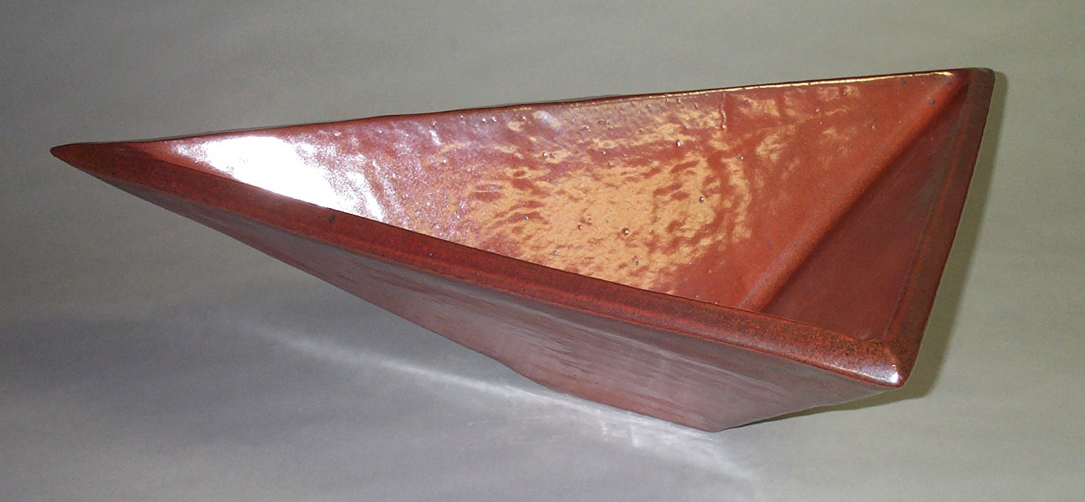 Red-glazed triangular ceramic bowl