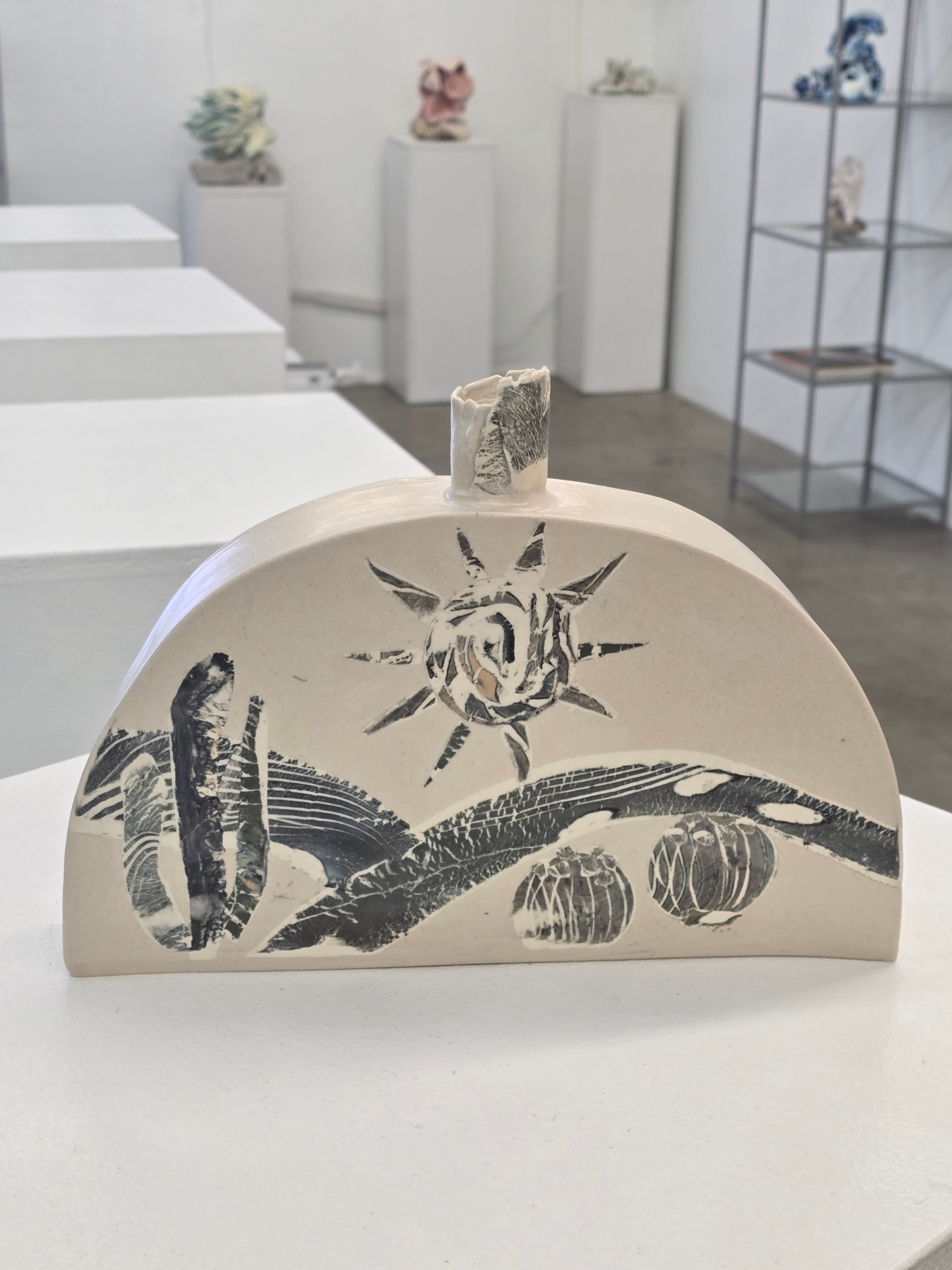 Arched ceramic vessel with sun motif