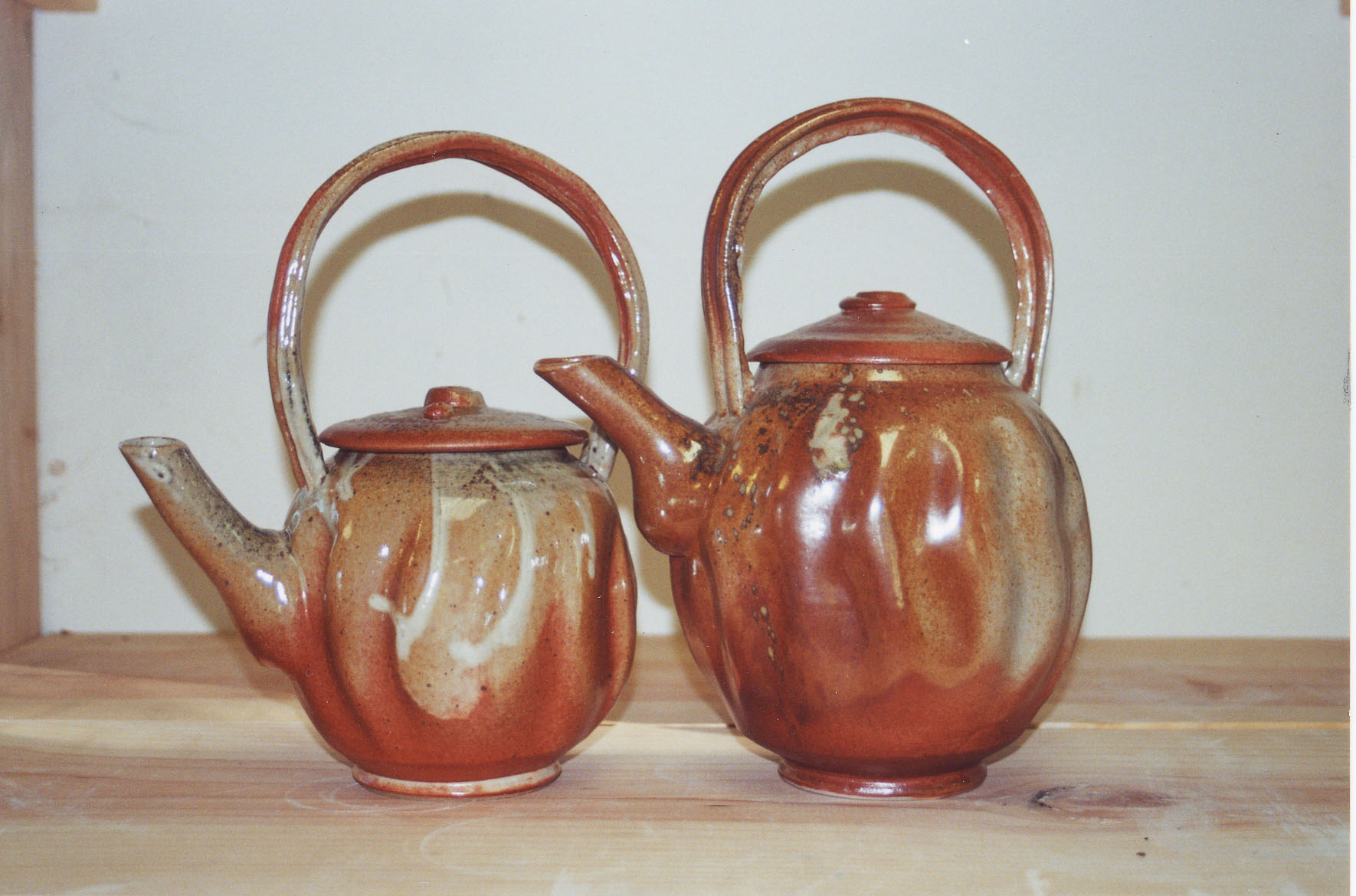 Two woodfired teapots with arched handles